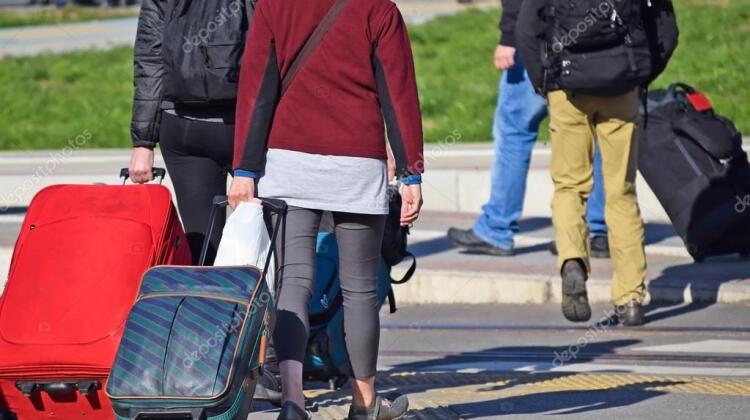 depositphotos_91115940-stock-photo-young-people-walking-with-suitcases
